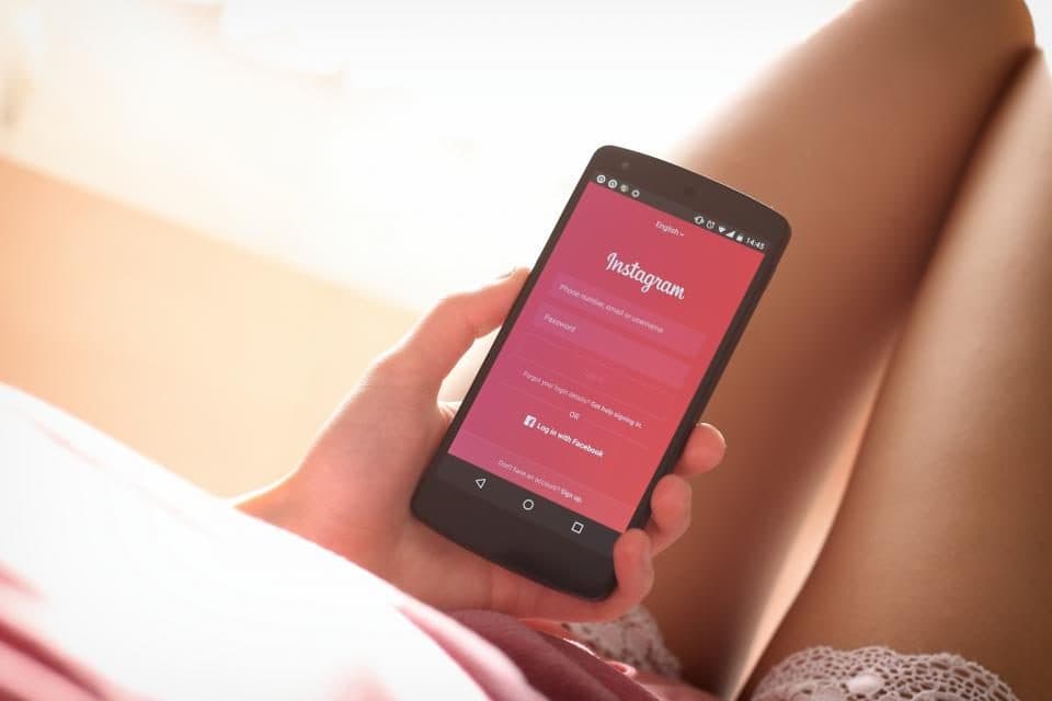 Hand holding a smartphone with the Instagram app open