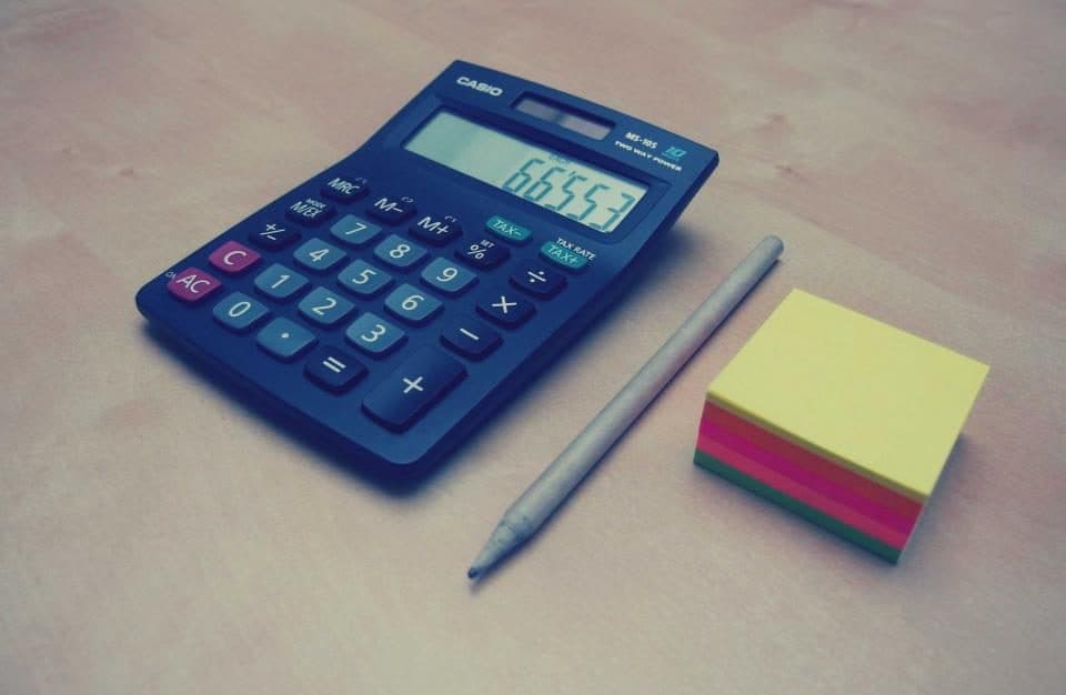 Calculator with a pencil and sticky notes on a desk